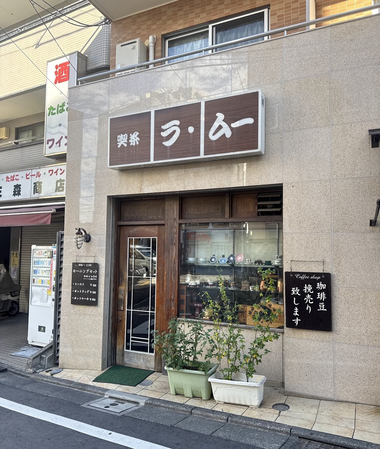 「喫茶 ラ・ムー」の茶色い看板と木製ドア、店頭の黒板に「珈琲豆 挽売り致します」の文字
